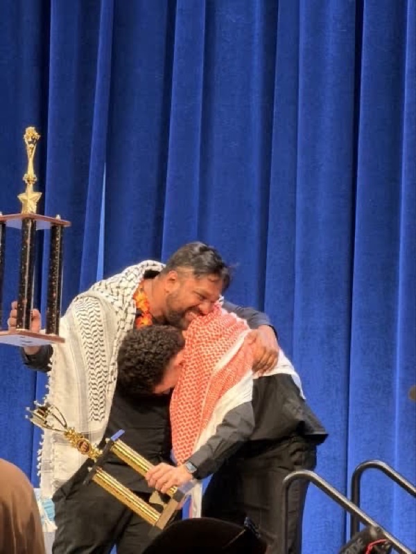 Emotional hug on stage with trophy