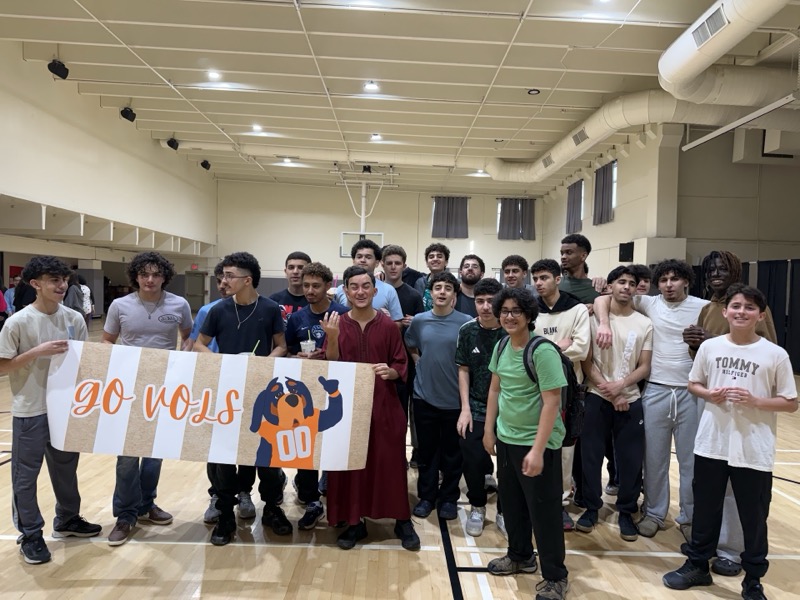 Boys with GO VOLS banner in gym